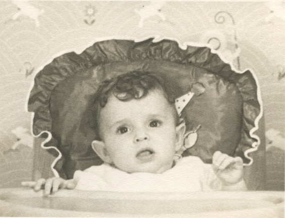 Carole Lee 1940 in her high chair with bo peep wall paper behind
