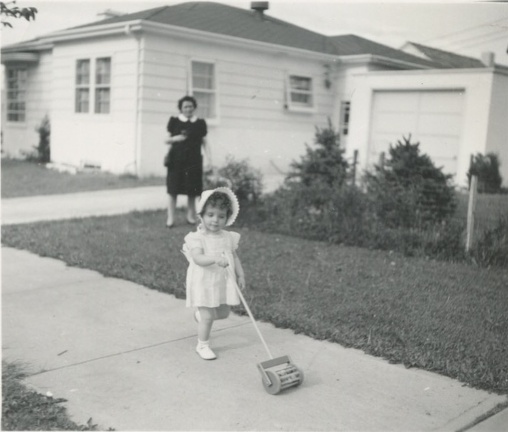 Carole and Cora 1943?pushing a push toy outside