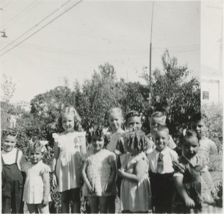 Lynn and Carole Stanard wearing matching bows and standing with friends 1945 or 1946